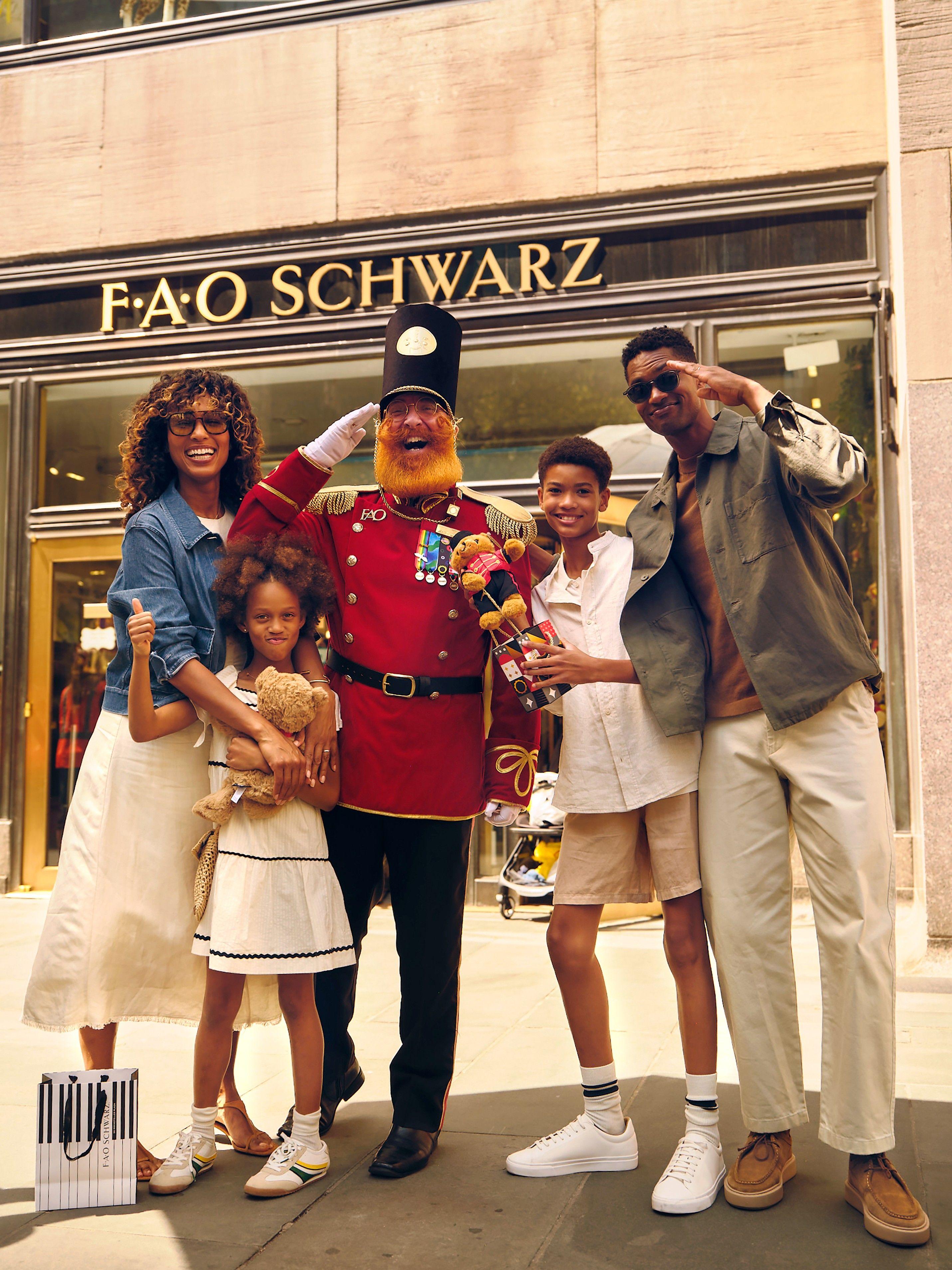 a family smiling in front of fao schwarz